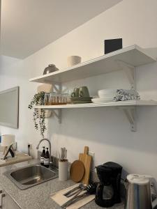 a kitchen counter with a sink and shelves on the wall at Tagaytay Staycation House Casa del Cielo - Near Skyranch in Tagaytay