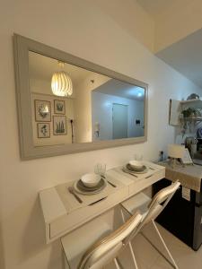 a dining table with two chairs and a large mirror at Tagaytay Staycation House Casa del Cielo - Near Skyranch in Tagaytay +15 photos