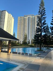 a swimming pool in front of some tall buildings at Tagaytay Staycation House Casa del Cielo - Near Skyranch in Tagaytay