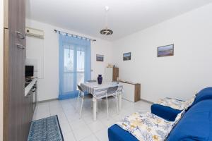 a living room with a table and a blue couch at villetta rosa blu marina di modica in Marina di Modica