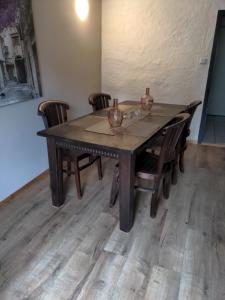 a wooden table with chairs and vases on it at 4 persons wohnung in de Eifel in Baustert