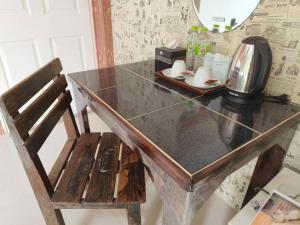a wooden table with a chair and a mirror at TC House and Cafe in Chiang Mai