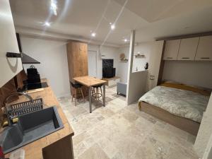 a bedroom with a bed and a kitchen with a sink at Charmant appartement in Nancy