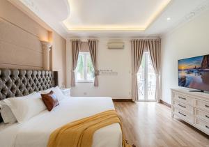 a bedroom with a large bed and a television at Luxury 4-Bedroom Villa with Private Pool & Billiards Table in Ho Chi Minh City