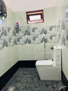 a bathroom with a white toilet and a window at Mandara Villa Hiriketiya in Dickwella