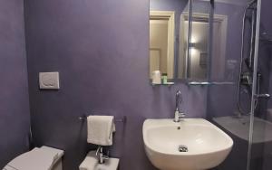 łazienka z umywalką, toaletą i lustrem w obiekcie Hotel Sorella Luna w Asyżu