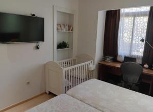 1 dormitorio con cuna, escritorio y TV en Marrakech al hamraa, en Marrakech 48 fotos más