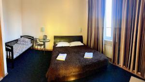 a bedroom with a bed and a table and a window at Mini-Hotel Sakvoyage in Chernivtsi