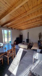 a living room with a wooden ceiling and a room with a couch at Teta's Holiday Home in Melíkia