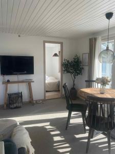 Una sala de estar con una mesa y un dormitorio. en Cottage In Scenic Natural Surroundings, en Vordingborg