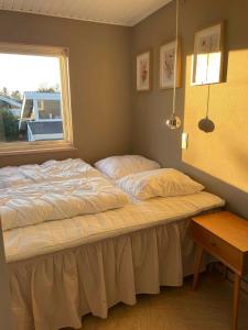 Una cama en un dormitorio con ventana. en Cottage In Scenic Natural Surroundings, en Vordingborg