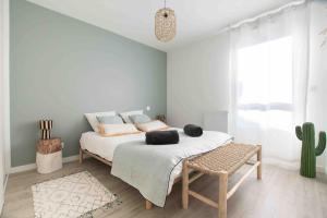 - une chambre avec un lit et un cactus dans l'établissement Le Bonamour - Élégance et sérénité entre plage et port, à Capbreton