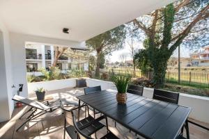 d'une table à manger et de chaises noires sur le balcon. dans l'établissement Le Bonamour - Élégance et sérénité entre plage et port, à Capbreton