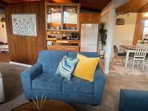 a living room with a blue couch and a kitchen at Western Cabin in Corvallis