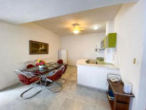 a kitchen with a table and chairs in a room at Hotel Suites Jazmín Acapulco in Acapulco