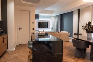 a living room with a kitchen and a living room with boxes at Prada Penthouse at On Park Century City in Cape Town