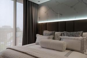 a bedroom with a white bed with a large window at Prada Penthouse at On Park Century City in Cape Town
