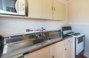 a kitchen with a sink and a microwave at Astral Motel in Whanganui