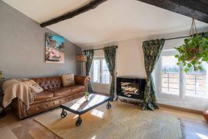 a living room with a leather couch and a fireplace at Sun dreams, centre ville historique, 10 minutes de Cannes in Vallauris