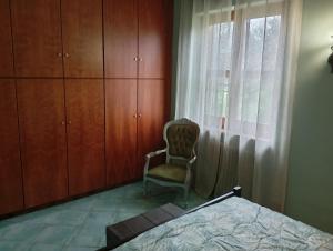 a bedroom with a bed and a chair next to a window at Casale del sole in Palestrina