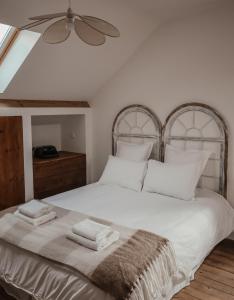 ein Schlafzimmer mit einem weißen Bett mit zwei Handtüchern darauf in der Unterkunft Maison en bord de Dordogne in Bergerac