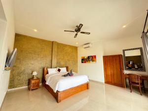 a bedroom with a bed and a ceiling fan at Martika Beach in Amed