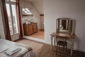 ein Schlafzimmer mit einem Spiegel und einem Tisch mit einem Stuhl in der Unterkunft Maison en bord de Dordogne in Bergerac + 26 Fotos