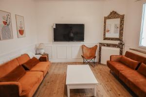 ein Wohnzimmer mit Sofa und Fernseher in der Unterkunft Maison en bord de Dordogne in Bergerac
