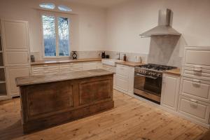 eine Küche mit weißen Schränken und einem Herd mit Backofen in der Unterkunft Maison en bord de Dordogne in Bergerac