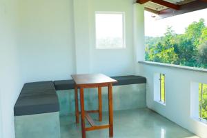 a small table and stool in a room with a window at Zephyr Heights in Ahangama
