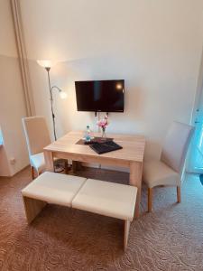 a room with a desk with two chairs and a television at Hotel Hieronimi in Cochem