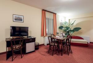 a hotel room with a table and chairs and a bed at Rooms Villa Iva in Ilok
