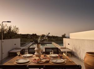 a table with glasses of wine on a patio at Pιgeon Nest Villa in Psarou