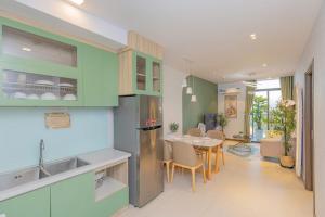 a kitchen and dining room with green cabinets and a table at Condotel CSJ Vũng Tàu - Apartment Luxury CSJ Vung Tau in Vung Tau