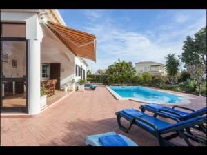 uma casa com piscina e algumas cadeiras em Villa Vilamar em Porches