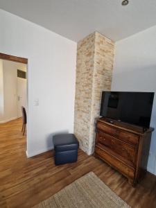 a living room with a flat screen tv on a wooden entertainment center at Ferienwohnungen Dümmersee - Haus Dümmerland - Wohnung 5 in Hüde