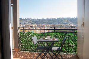 a table and chairs on a balcony with a view at A Casa di Amici in Naples