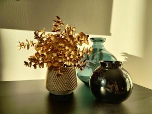 two vases sitting on a table with flowers in them at Modernes Loft-Erlebnis mit Fitnessbereich & Heimkino in Magdeburg