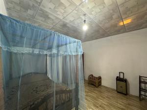 1 dormitorio con 1 cama con cortina azul en Southern Colonial Villa, en Matara
