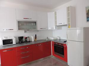 a kitchen with red cabinets and a white refrigerator at Apartment Ivana in Split