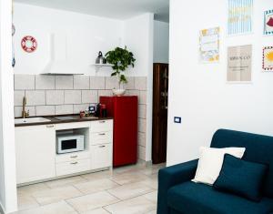 a kitchen with a red refrigerator and a blue couch at Casa Iside in Ladispoli