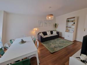 a living room with a white table and a couch at Appartement 4P 85m² hyper centre Disney in Chessy