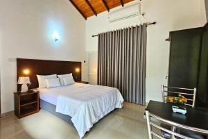 a bedroom with a large bed and a desk and a bed sidx sidx at Niwahana Holiday Resort in Polonnaruwa