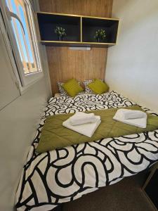 a bedroom with a bed with a black and white comforter at Mobile home Tortuga in Drage
