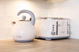 a tea kettle next to a toaster on a counter at Beautifully refurbished 3 bedroom cottage in Ashdon
