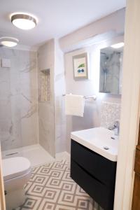 a bathroom with a sink and a toilet and a shower at Beautifully refurbished 3 bedroom cottage in Ashdon +8 photos
