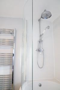 a shower with a glass door in a bathroom at Beautifully refurbished 3 bedroom cottage in Ashdon