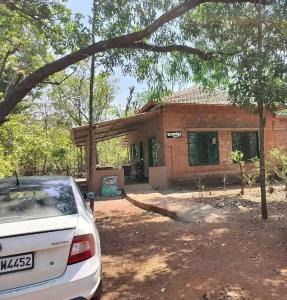 a car parked in front of a house at Jungle home stay in Devrukh