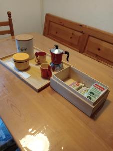 a wooden table with a tray with a tea kettle and cups at Il nido luminoso in Riomaggiore