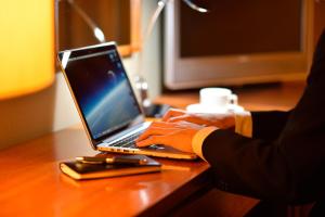 a person typing on a laptop computer on a desk at Hotel Royal Morioka in Morioka